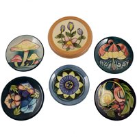 Lot 560 - A collection of eleven Moorcroft Pottery coasters, and a pin dish.