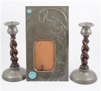 Lot 242 - An Arts and Crafts pewter picture frame with Ruskin style roundels, and two pewter mounted candlesticks