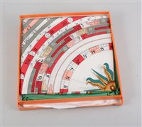 Lot 170 - An Hermes "Astrologie" pattern silk scarf, green and gold border, titled "Dies Et Hores" to centre, Hermes-Paris to bottom centre, rolled edges,stitched label, with orange Hermes box.