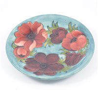 Lot 7 - A Moorcroft "Anemone" shallow dish on smokey blue/green ground, 25.5cm, signed and impressed Moorcroft Made in England.