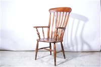 Lot 415 - An elm and beech fireside chair.