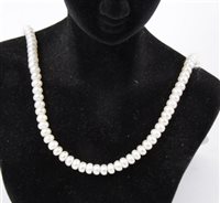Lot 214 - A cultured pearl necklace, the 5.2mm button shaped pearls strung into a necklace 47cm long and fitted with a 9 carat yellow gold safety hook fastener set with a 7mm pearl