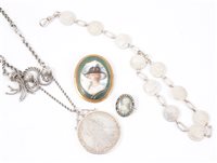Lot 211 - Two portrait miniature style brooches, a silver four pence coin bracelet, Maria Theresa coin pendant on a silver coloured watch albert style chain