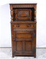 Lot 414 - Reproduction oak court cupboard, of small size, carved decoration, arcaded panelled door under a recess with a single drawer and panelled door, width 61cm, height 132cm