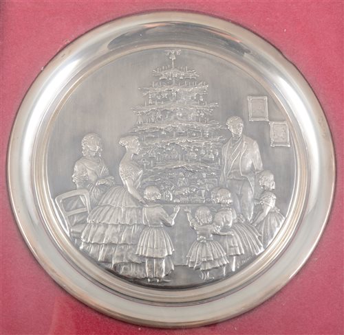 Lot 186 - Silver Christmas plate, moulded and framed, embossed with a scene of a Victorian family round a tree, diameter 19cm, cased