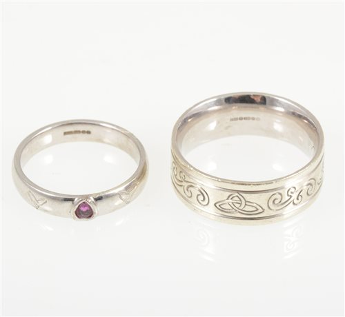 Lot 226 - Two gold rings - a 9 carat white gold 8.2mm wide band engraved with a celtic design, ring size U, approximate weight 10.6gms, a 9 carat white gold 4mm wide plain polished D shape band