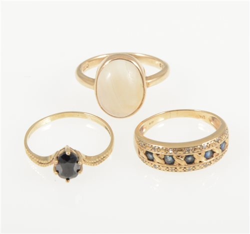 Lot 240 - A 9 carat yellow gold ring set with five sapphires and a diamond border to each side, ring size M, a 9 carat yellow gold ring set with an oval cabochon translucent stone size O
