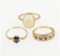 Lot 240 - A 9 carat yellow gold ring set with five sapphires and a diamond border to each side, ring size M, a 9 carat yellow gold ring set with an oval cabochon translucent stone size O