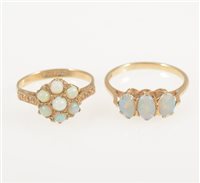 Lot 225 - A 9 carat yellow gold ring set with three oval cabochon opals, ring size M and a 9 carat yellow gold circular cluster ring set with seven round cabochon cut opals, ring size L. (2)