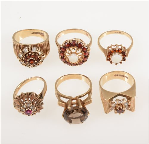 Lot 242 - Six retro 1960's/1970's 9 carat yellow gold gemset dress rings, smoky quartz, garnet, opal and synthetic white spinel, some with bark textured shoulders, ring sizes L-O