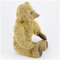 Lot 208 - Early 20th century jointed teddy bear, long golden mohair body with glass eyes and jointed limbs, stitched nose, leather pad feet and paws, with defective growler, 34cm tall.