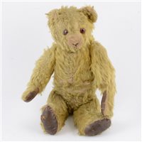 Lot 208 - Early 20th century jointed teddy bear, long golden mohair body with glass eyes and jointed limbs, stitched nose, leather pad feet and paws, with defective growler, 34cm tall.
