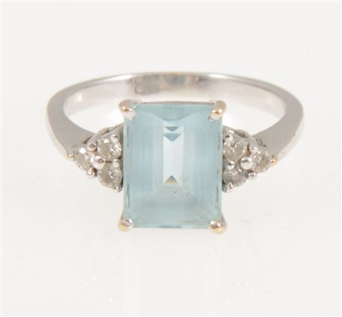 Lot 216 - An aquamarine and diamond ring, the rectangular mixed cut stone, 9.8mm x 7.4mm, four claw set with three small diamonds set to each side
