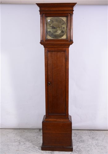 Lot 139 - Oak longcase clock, moulded cornice, plain frieze, the hood with three quarter turned columns, long door, plinth base, 11" square brass dial, with cast seraphim spandrels, chapter ring with Roman n...