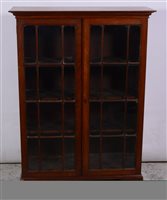 Lot 345 - Oak bookcase, rectangular top above a dentil and cavetto moulded cornice, glazed doors enclosing shelves, bracket feet, width 98cm, depth 35cm, height 138cm.