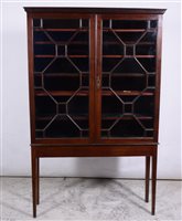 Lot 342 - Mahogany cabinet on stand, key and cavetto moulded cornice, astragal glazed doors enclosing shelves, the base with square tapering legs, adapted, width 110cm, depth 28cm.