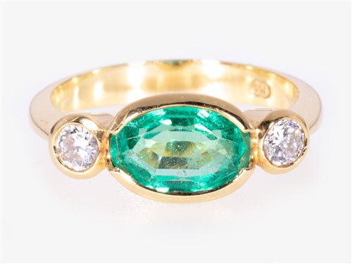 Lot 170 - An emerald and diamond three stone ring.