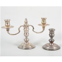 Lot 180 - A two-light silver candelabra by William Comyns & Sons Ltd, round base, broad drip pans, London 1972, 16cm high, 27cm diameter; and a single candlestick by the same maker, London 1972, 11cm high. (2)