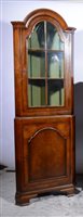 Lot 348 - Reproduction walnut freestanding corner cabinet, arched top, the upper section with glazed door, panelled door below, ogee bracket feet, width 64cm, height 183cm.
