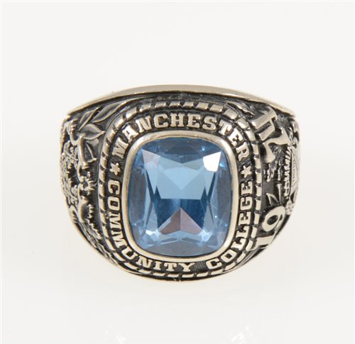 Lot 227 - An American college ring "Manchester Community College 1974" set with a rectangular synthetic blue spinel, shank marked 10K Jostens, gross weight approximately 19.2gms, ring size R.