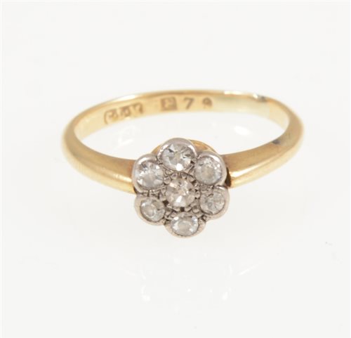 Lot 214 - A circular diamond cluster ring, seven old eight cut diamonds milgrain set in a yellow and white metal mount, shank marked 18, ring size O.