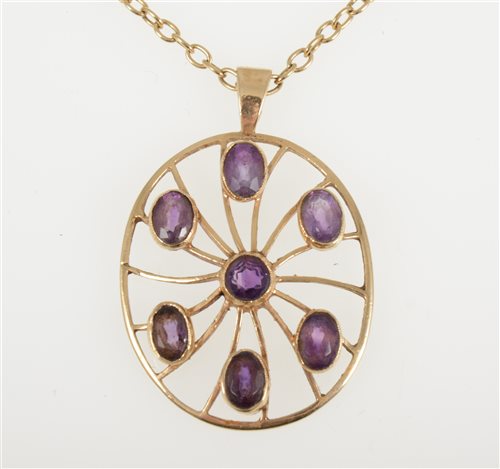 Lot 251 - A 9 carat yellow gold oval pendant 36mm x 30mm collet set with seven amethyst, hallmarked London 1976 on a yellow metal oval trace link chain 58cm long, total weight approximately 13.5gms.