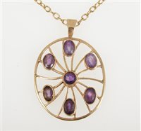 Lot 251 - A 9 carat yellow gold oval pendant 36mm x 30mm collet set with seven amethyst, hallmarked London 1976 on a yellow metal oval trace link chain 58cm long, total weight approximately 13.5gms.