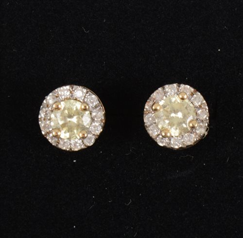 Lot 262 - A pair of circular diamond cluster earrings, the centre set with a yellow brilliant cut diamond and surrounded by twelve white brilliant cut diamonds