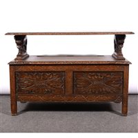 Lot 439 - An oak monks bench, carved panels and borders.