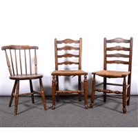 Lot 444 - Two ash and stained wood ladder-back dining chairs, with rush seats, and an elm and beechwood comb-back dining chair, (3).