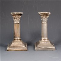 Lot 175 - A pair of Victorian silver Corinthian column-style candlesticks by Hawksworth, Eyre & Co Ltd, Sheffield 1891, 15cm high on square stepped weighted bases.