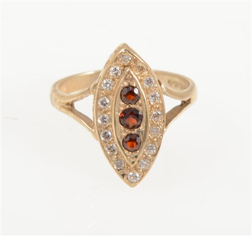 Lot 209 - A modern 9 carat yellow gold marquise cluster ring set with three vertical garnets and a border of sixteen synthetic white stones, ring size O.