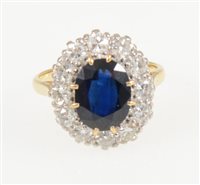 Lot 217 - A sapphire and diamond oval cluster ring, the oval mixed cut sapphire 10mm x 8mm, claw set and surrounded by twelve brilliant cut diamonds