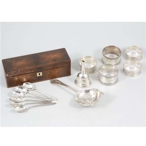 Lot 384 - A set of six silver coffee spoons by Hukin & Heath Ltd, Birmingham 1923; five silver napkin rings, a silver funnel; a silver tea strainer with pierced handle