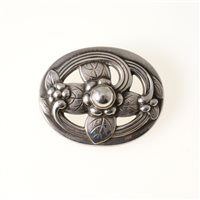 Lot 338 - Georg Jensen - a silver brooch number 138, oval frame 40mm x 30mm, with a stylised leaf and flower having a polished bead to the centre, hallmarked London 1982. approximate weight 0.34oz.