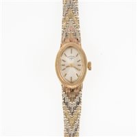 Lot 323 - Rotary - a lady's 9 carat gold bracelet watch, the oval baton dial in a 9 carat yellow gold case with bark textured bezel