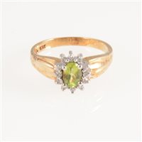Lot 248 - A peridot and diamond oval cluster ring, the oval mixed cut peridot surrounded by twelve eight cut diamonds in a yellow and white metal mount marked 10K, ring size N.
