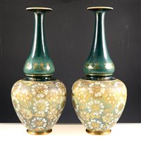 Lot 20 - A pair of Doulton silicon style bottle neck vases on a green ground with gilded highlights, 42cm. (2)