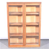 Lot 481 - An Edwardian stained wood bookcase, two glazed panelled doors enclosing shelves, width 72cm, height 103cm.
