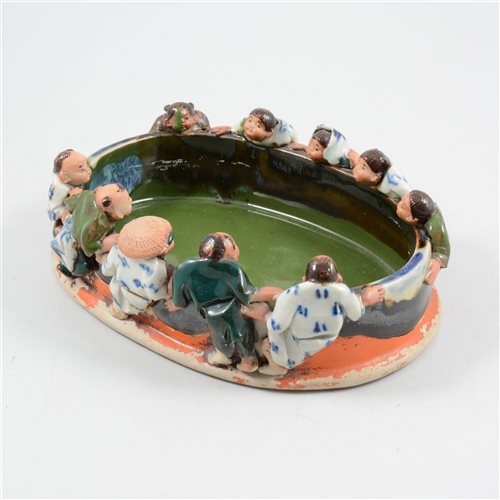 Lot 52 - A Sumida Gawa stoneware figural bowl, the rim with ten figures peering into the interior.