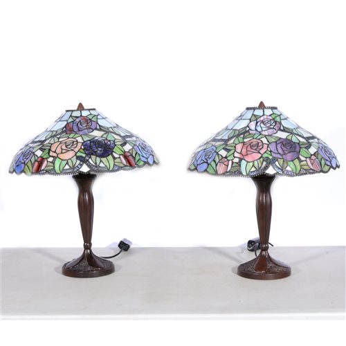 Lot 175 - A pair of modern Tiffany style table lamps, bronze effect rose design bases supporting coolie glass shades featuring green, blue and pink roses, overall height 50m. (2)