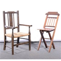 Lot 470 - Child's stained beechwood elbow chair, with a rush seat, 39cm;  and a child's folding chair, (2).
