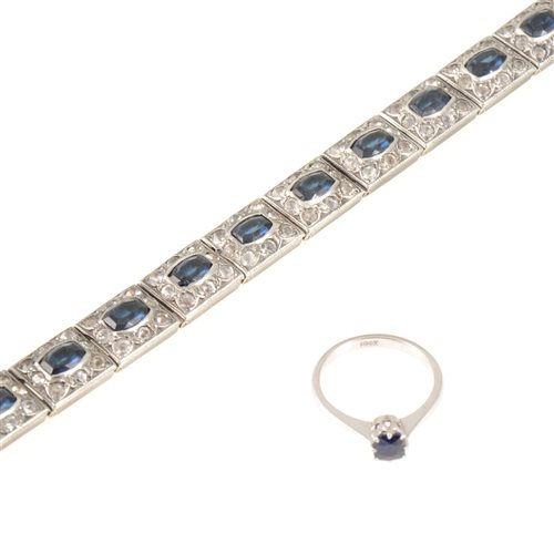 Lot 217 - A sapphire solitaire ring, the 4.5mm cushion shaped stone claw set in an all white metal mount, shank marked 18ct, ring size M,a paste set deco style bracelet