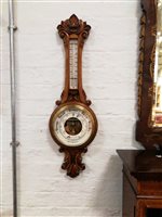 Lot 467 - E Marston Loughborough an oak cased aneroid wall barometer with thermometer, carved scrolls to top and bottom, overall 87cm