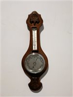 Lot 366 - A small oak cased aneroid wall barometer with thermometer, carved detail to top and bottom, overall 60cm.