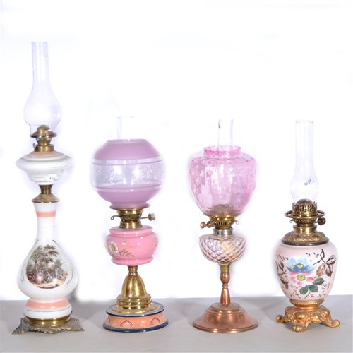 Lot 171 - Four oil lamps, to include Hink's No.1, pink and clear glass banded globe with floral decoration, pink reservoir with hand-painted flowers, brass column and pottery base, 58cm (4)