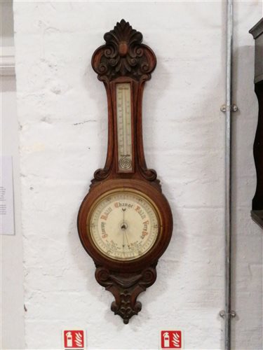 Lot 205 - A carved oak aneroid banjo shape barometer