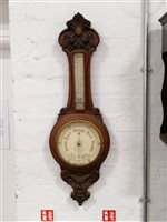 Lot 205 - A carved oak aneroid banjo shape barometer