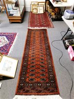 Lot 490 - Bokhara rug, two rows of eight elephant foot guls on a red field, and a runner.