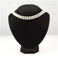 Lot 192 - A two row non-graduated cultured pearl necklace,  (49) (53), 6.5mm pearls, knotted every pearl into a necklace 43cm long and fitted with a silver fastener set with marcasite and a single pearl.